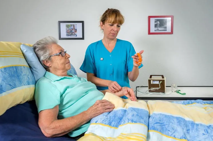 Pflegehelfende SRK misst den Puls einer Patientin